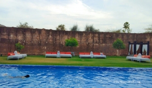 The pool and the luxurious diwans near the Amer fort wall - TheWingedFork