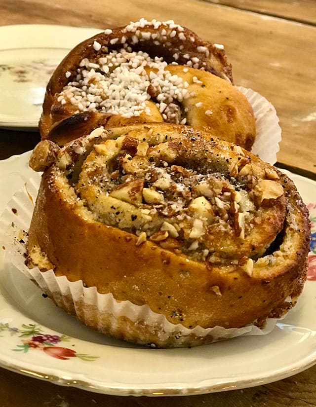 Kanelbullar topped with sugar and cinnamon in a plate.