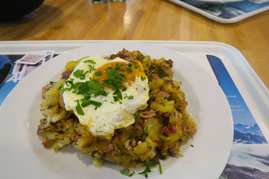 Fried onion, bacon and other small meat pieces are added to sauteed potatoes and topped with fried egg - Pic by Eniko from Travel Hacker Girl