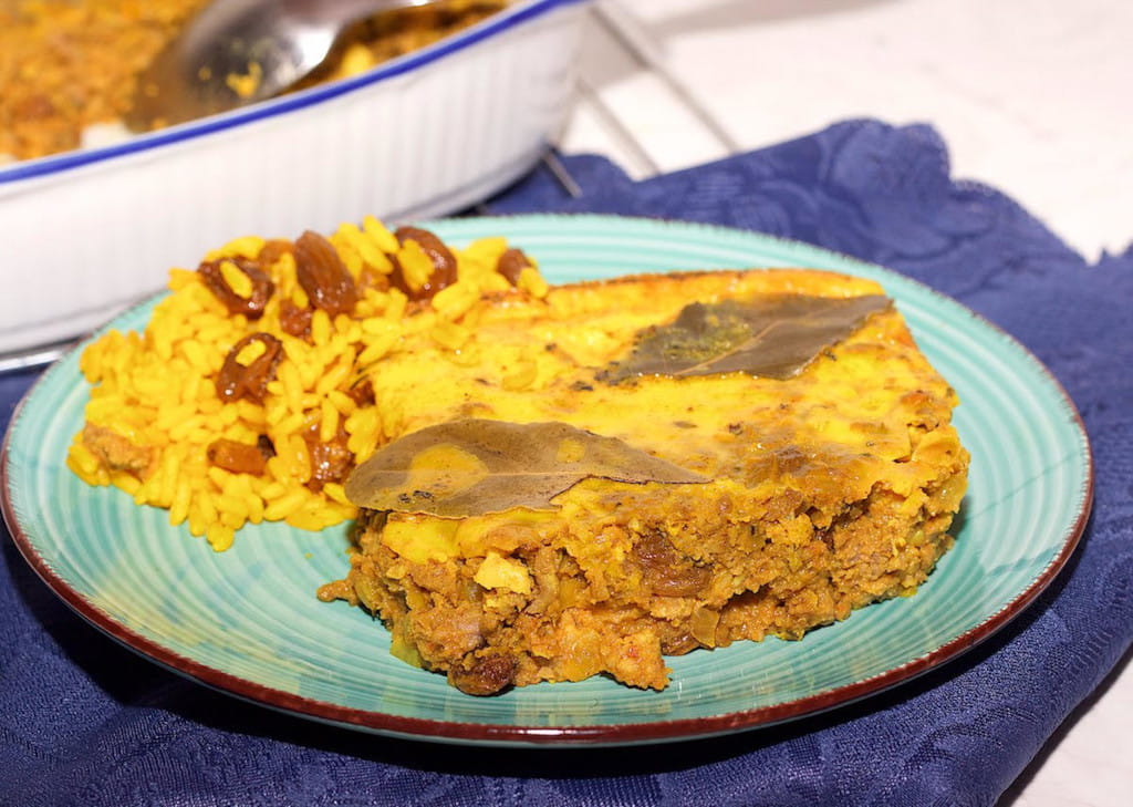 South African bobotie and rice in a blue plate.