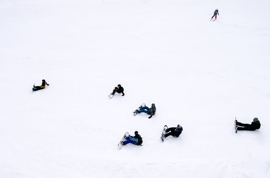 People snowboarding in the snow.