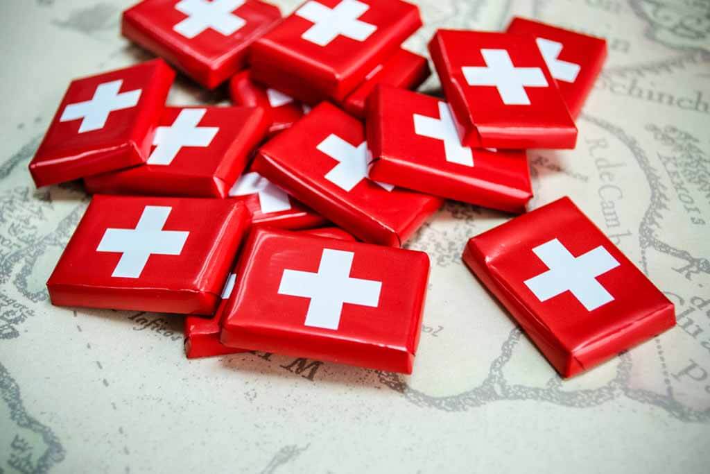 Pieces of chocolate with the red and white Swiss flag covering.