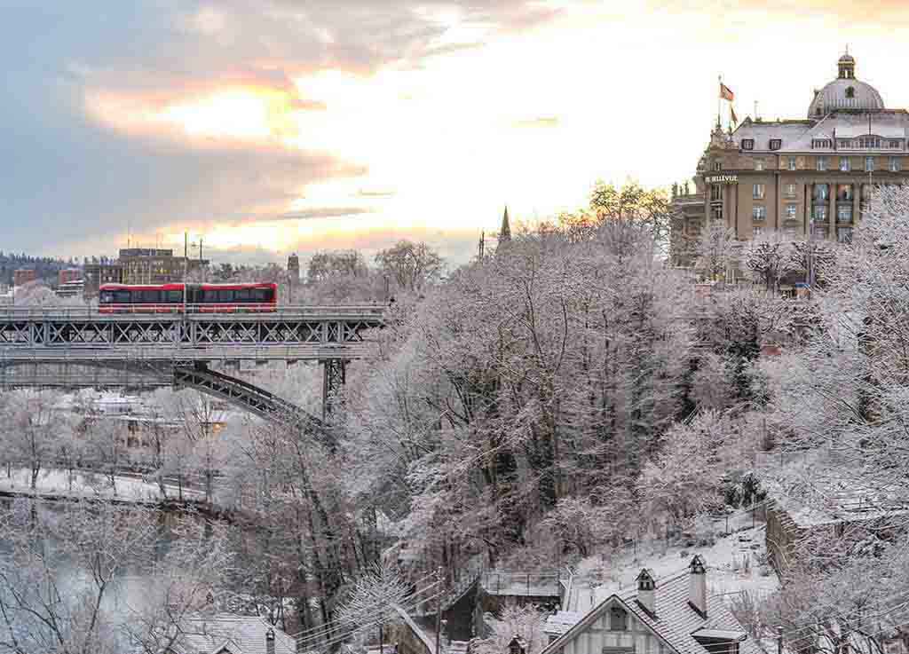 Train and trees covered with snow in Bern.