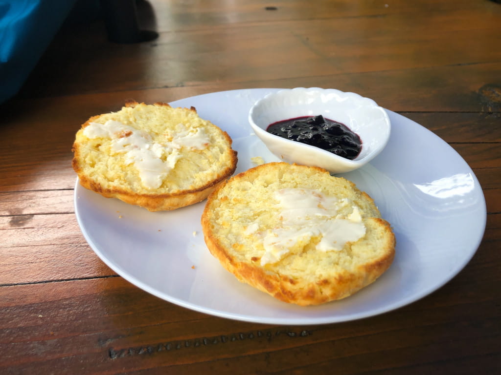 Bannock on a white plate with jam and butter.