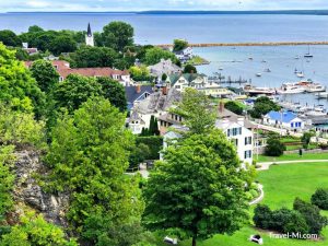 View of Mackinac island homes and beach from a hilltop.