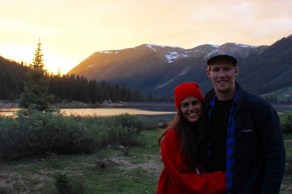 Pic of a guy and girl standing in front of a mountainous backdrop.
