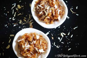 Apple halwa in white bowls with almond slices.