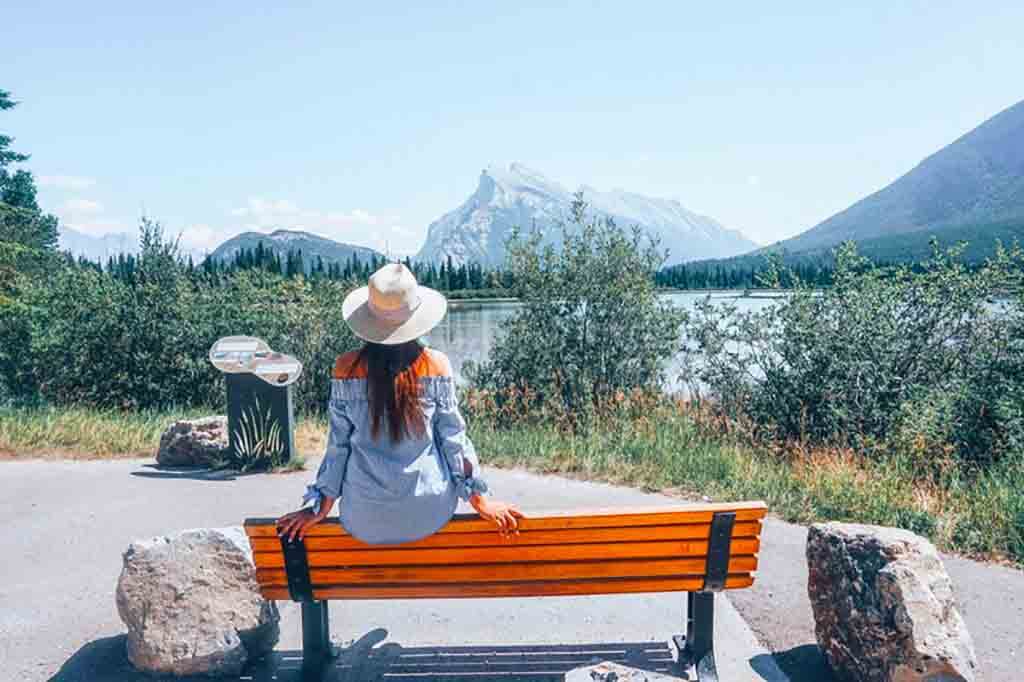 Girl sitting on a bench in Banff National Park in Canada.