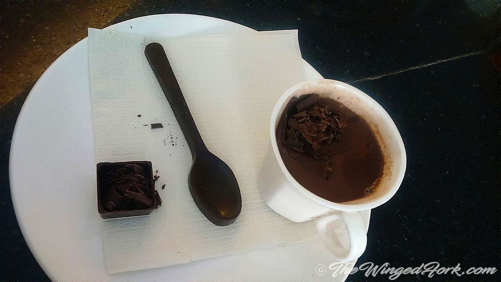 Hot chocolate with dissolvable spoon and grated chocolate.