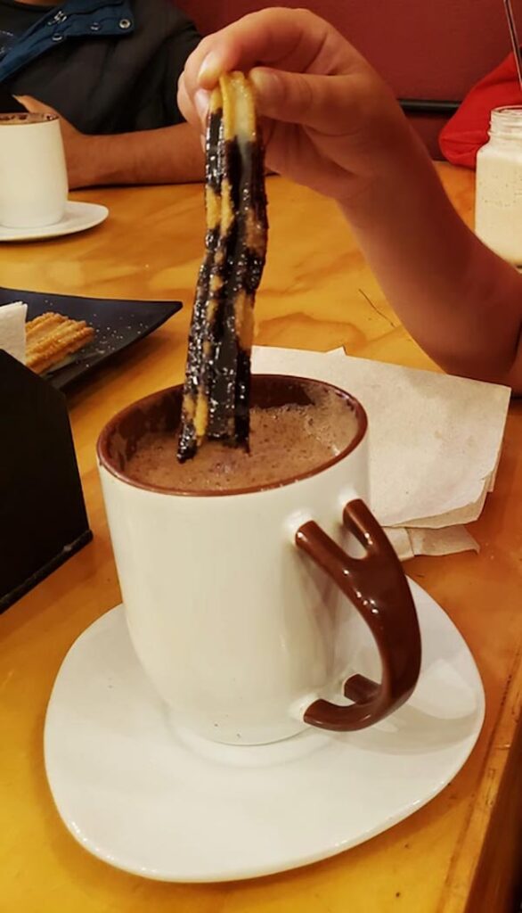 Dipping churros in hot chocolate.