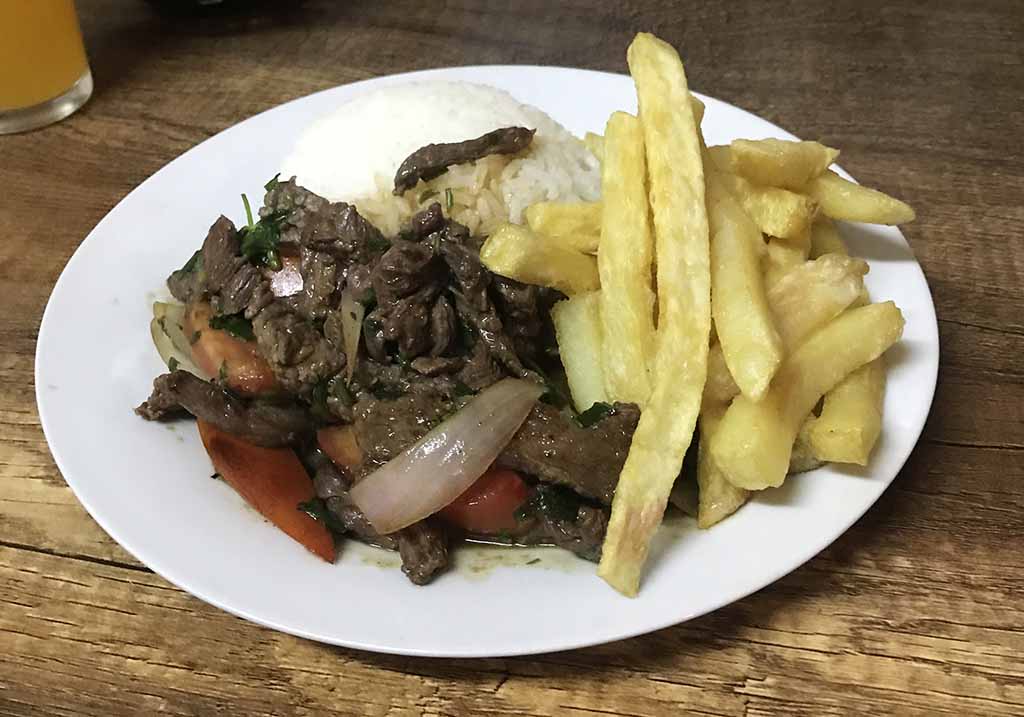 Beef, french fries and rice served in a stir fry-style dish.