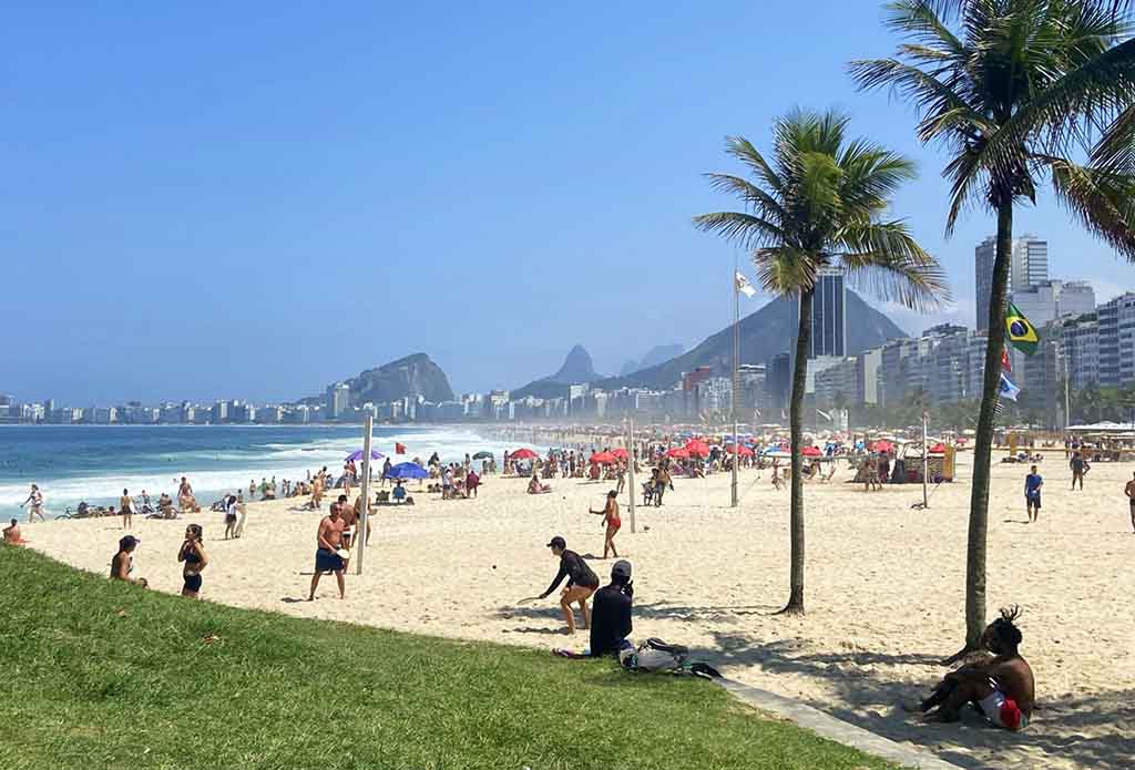 People playing footvolley and relaxing in Rio de Janeiro Beach.