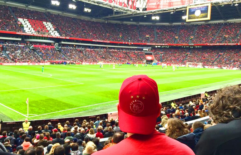 Person in an Ajax hat watching the Ajax Game.