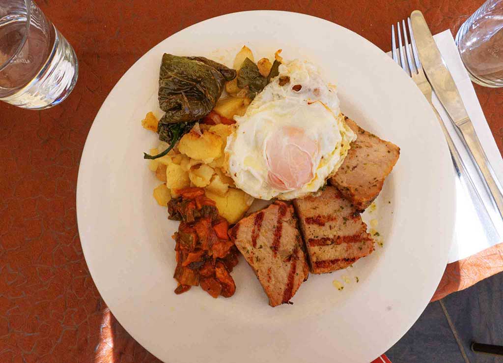 The dish consists of pork, sausage, black pudding, potatoes, peppers and eggs.